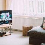 Chic and comfortable living room featuring a modern sofa, decorative pillows, and a TV streaming popular shows.